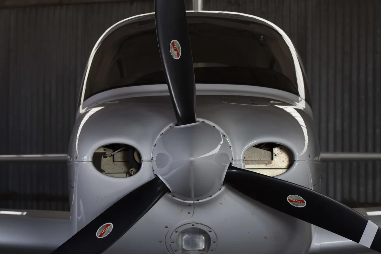 Front view of a Cirrus SR20 and its propeller inside a hangar