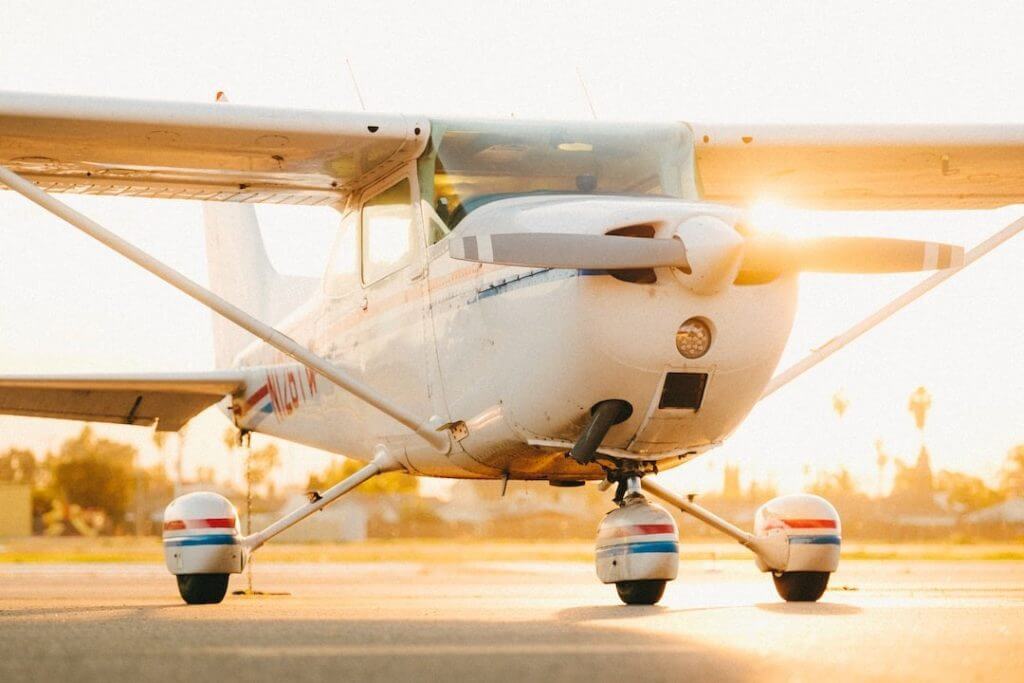 Single-engine training aircraft on an airport apron in warm evening light