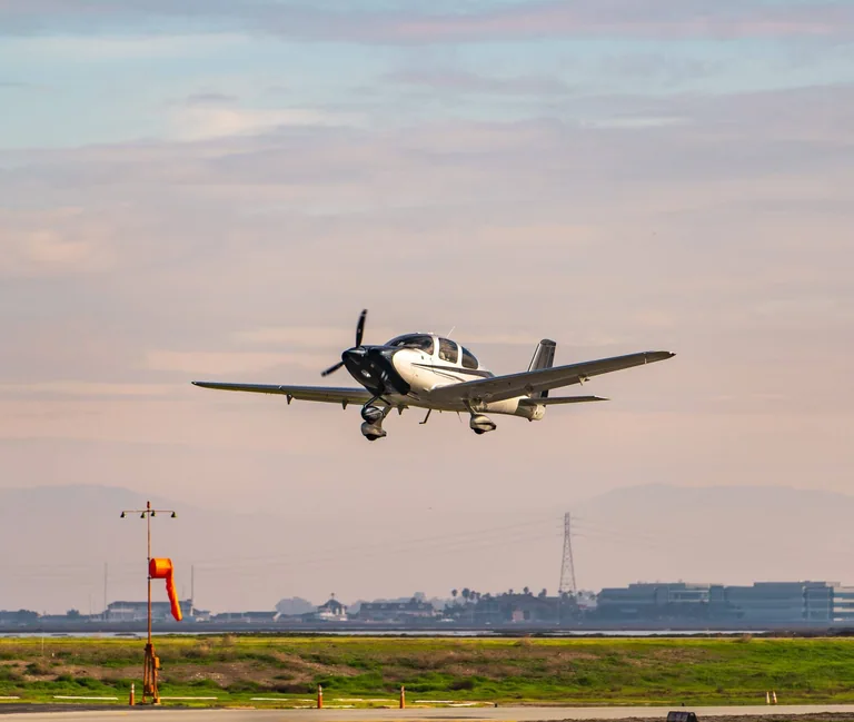A single-engine airplane approaching a runway