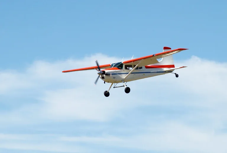 Cessna 180 aircraft approaching with landing gear extended