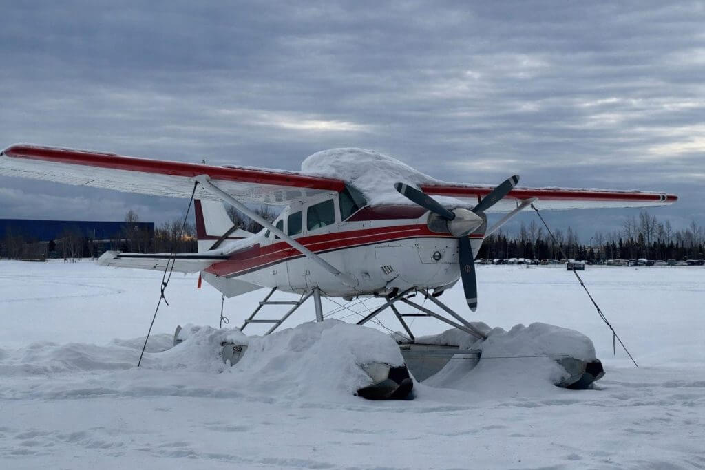 Float-equipped aircraft parked outdoors in winter