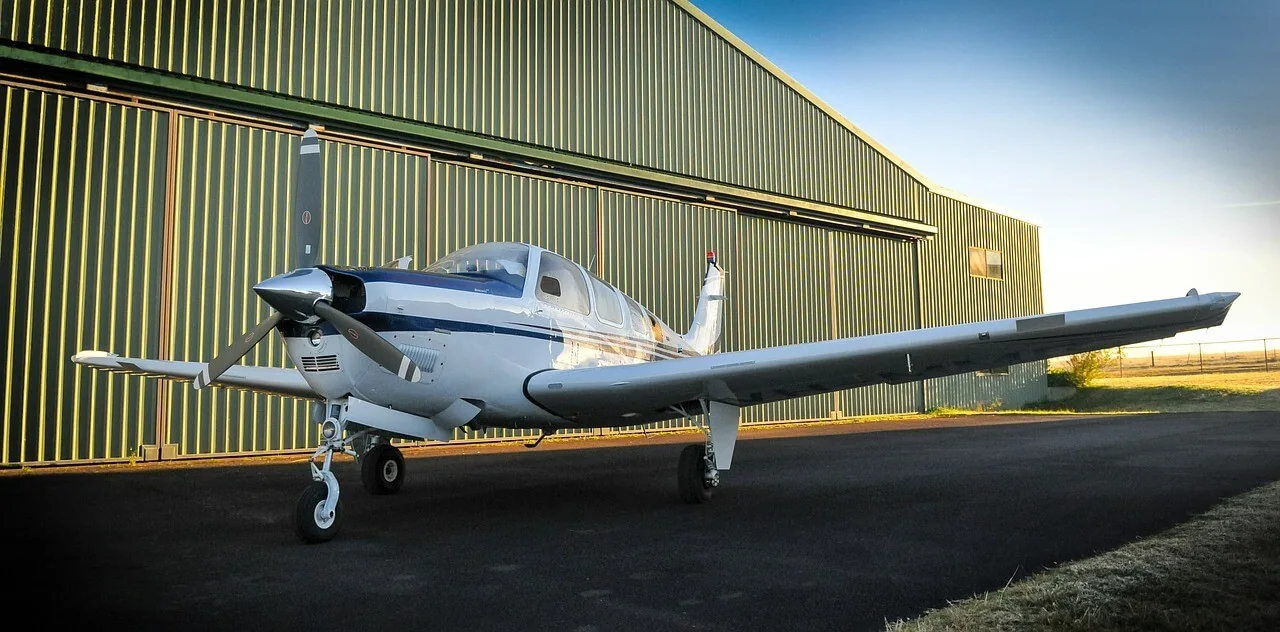 A single-engine aircraft parked outside a hangar