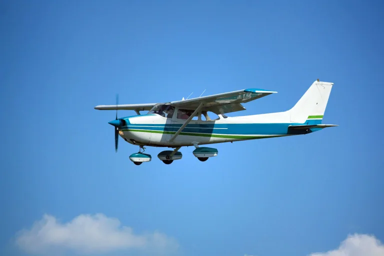A high-wing Cessna aircraft in flight