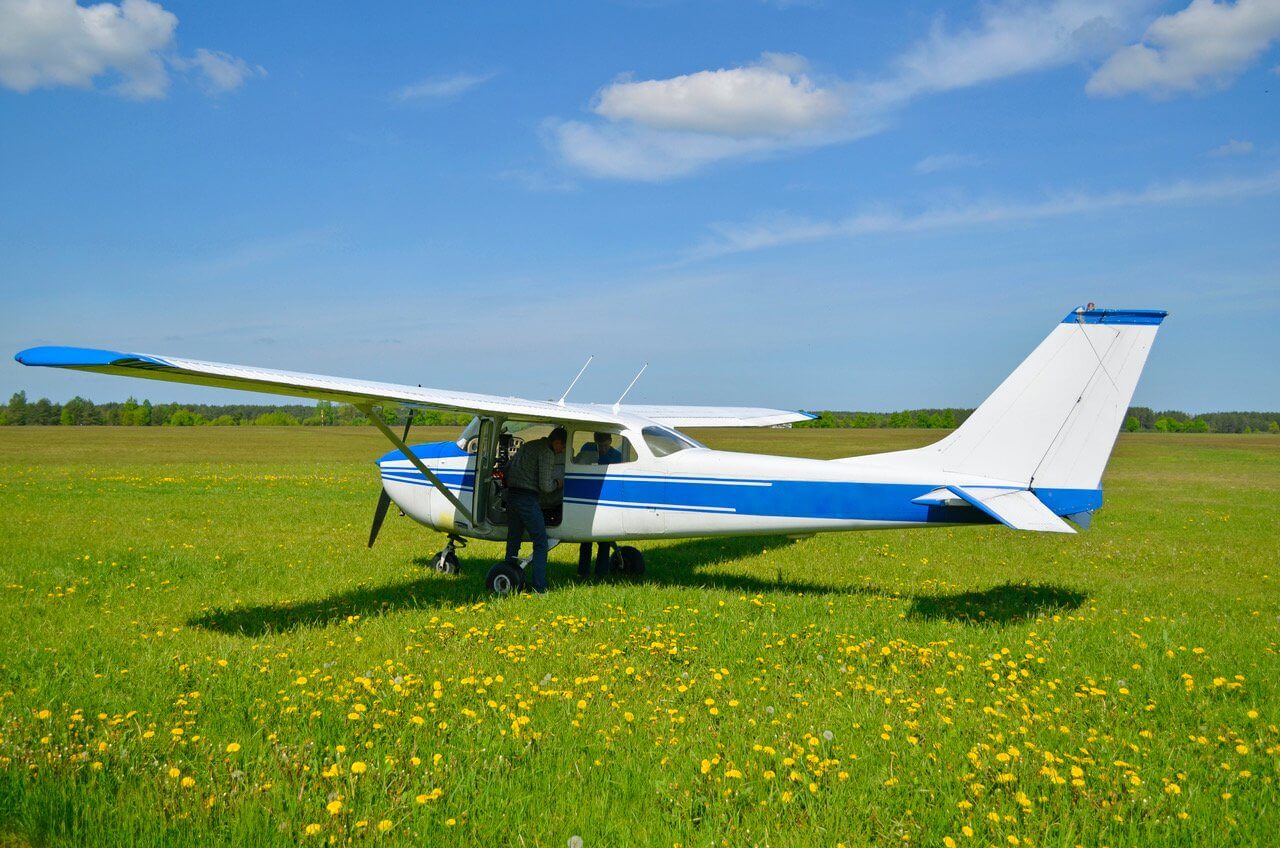 Small single engine airplane parked on grass
