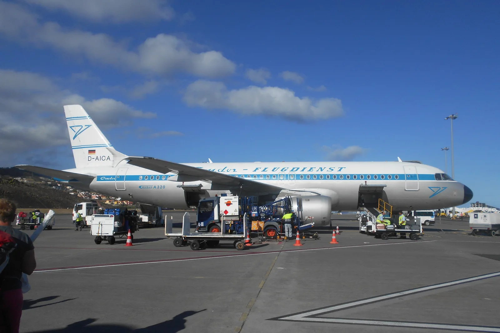 Ground personnel and service equipment around a Condor aircraft on the apron at Madeira Airport