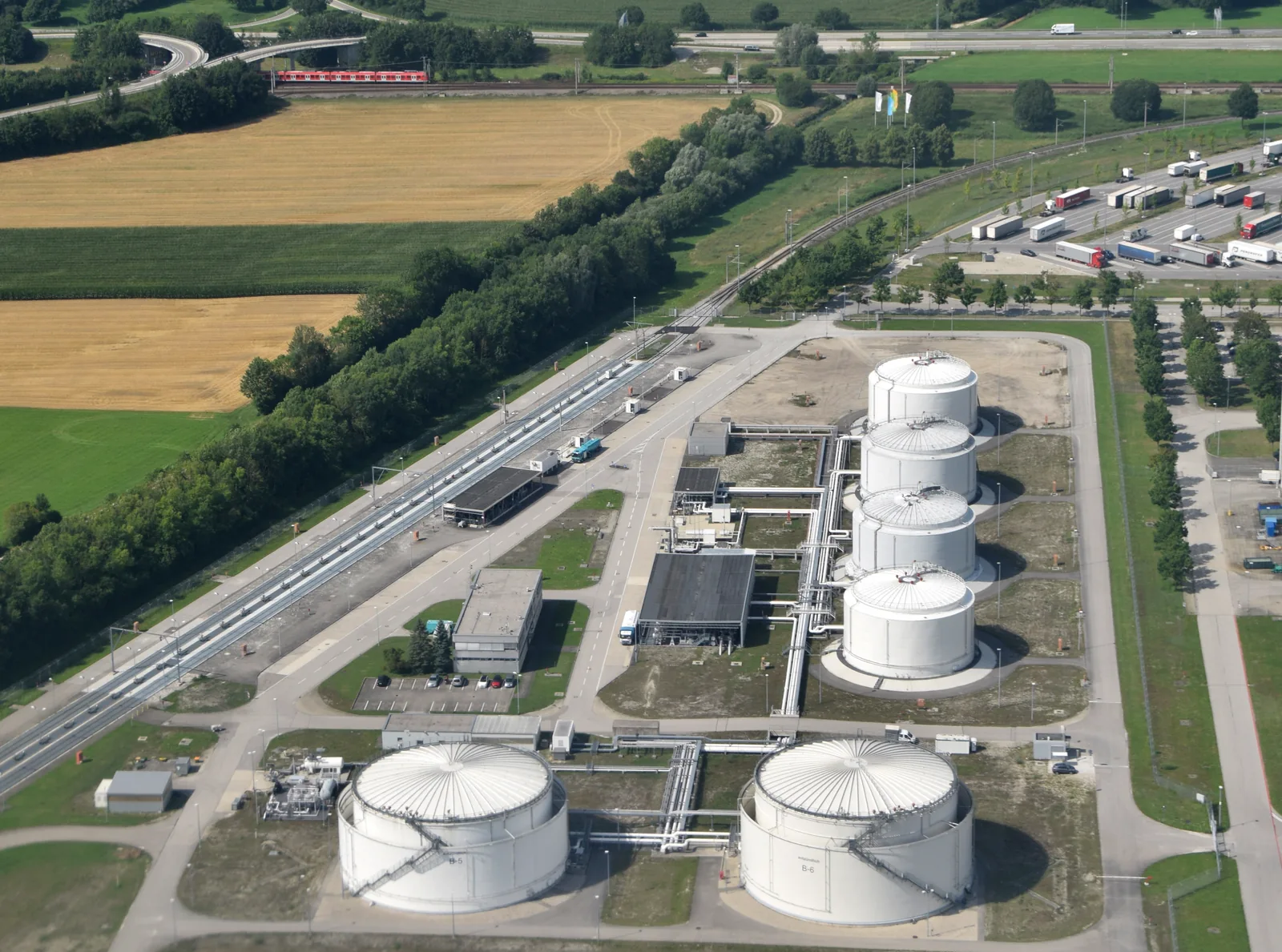Aerial view of cylindrical fuel storage tanks and pipework at Munich Airport in Germany