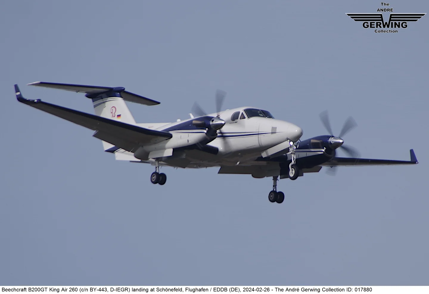 Twin engine turboprop airplane in flight with landing gear extended.