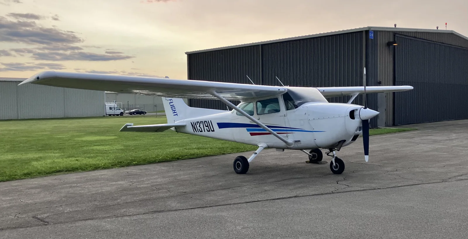 Cessna 172M N1379U parked beside hangars