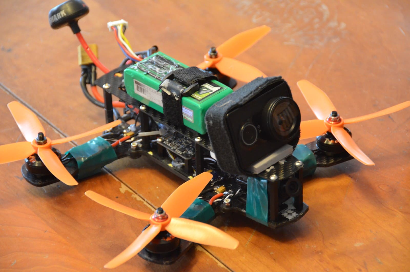 Minion 220 racing drone with orange propellers resting on a table