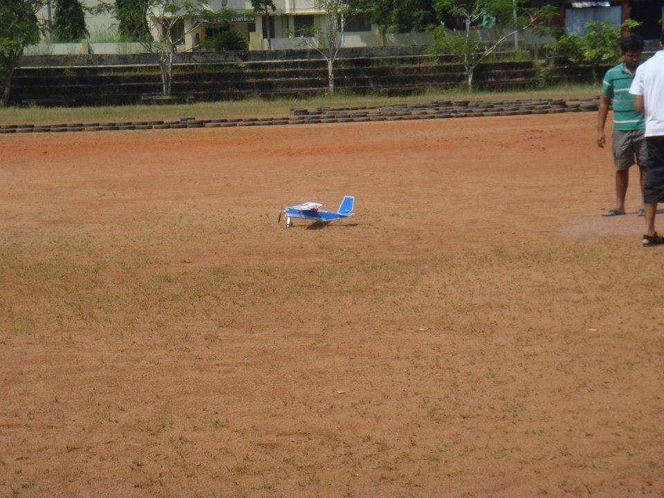 Radio controlled model airplane resting on a dirt flying field