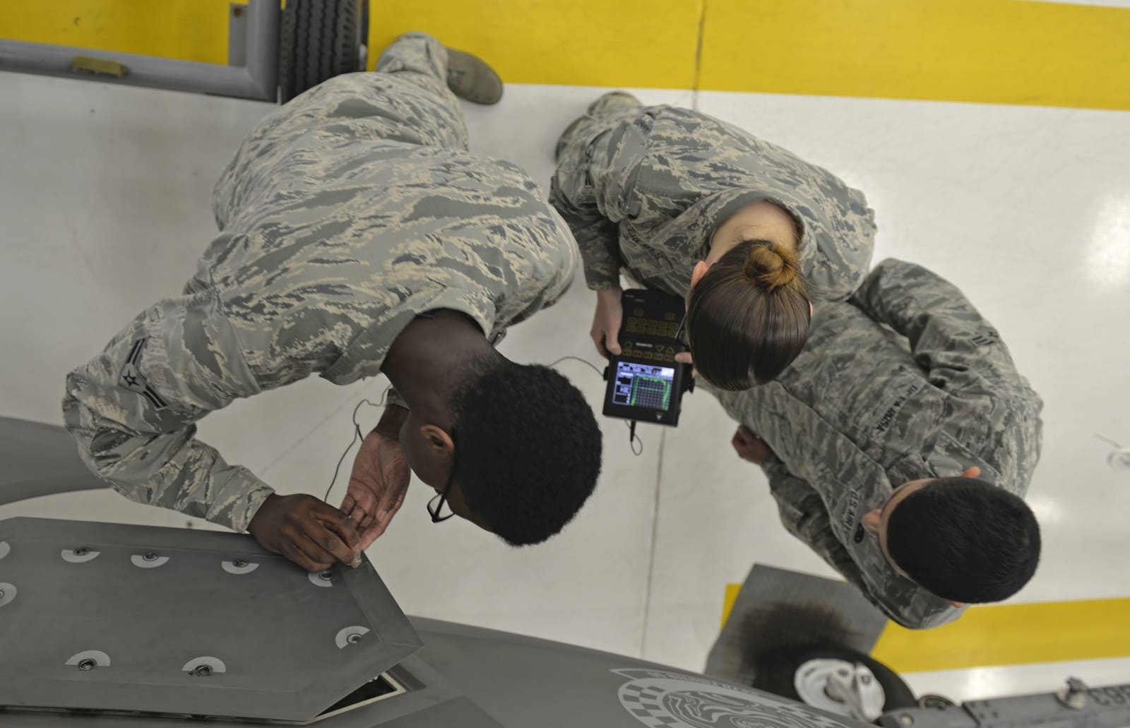 US Air Force inspection personnel examining an aircraft panel in 2016