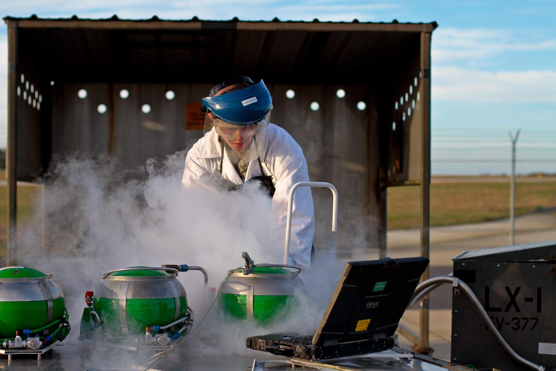 Air Force technician in protective clothing beside liquid oxygen servicing equipment in2013